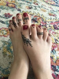 a woman's feet with tattoos on them and her toenails are shown