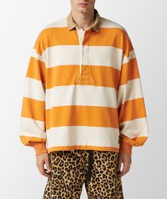 A vintage piece of sportswear, now even bigger to match its style. KAPITAL presents this oversized rugby polo shirt with a beige and orange wide striped motif, a button-down polo collar, an adjustable drawstring hem and ribbed cuffs. The circular stitching in the center of the chest and the brand logo on the left side of the hem are distinctive details that add character to an already timeless garment. Button Down Polo, Rugby Polo, Striped Jersey, Button Down, Shirt Model, Wide Stripes, Polo Collar, Saudi Arabia, Rugby