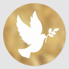 a white dove with a twig in its beak on a gold circle sticker