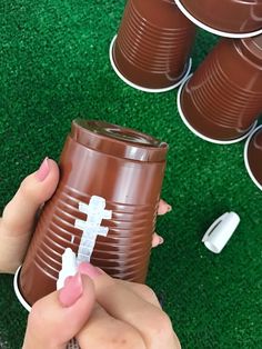 a person holding a plastic cup with a cross on it and several cups in the background