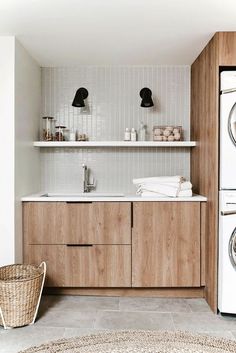 a washer and dryer sitting next to each other in a room with wooden cabinets