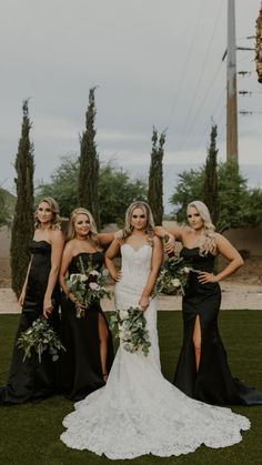 four bridesmaids in black dresses posing for the camera