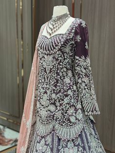 Indulge in luxury with our English Violet Purple Empress Lacha Collection. This exquisite peplum-style lacha features stunning silver work and a blush net dupta. Drape yourself in elegance and sophistication with this one-of-a-kind piece. Elevate your wardrobe with the artful fusion of English and Indian styles. Fabric: Velvet & Organza! WASH CARE INSTRUCTIONS - Please Dry clean only when it is applicable. Ready to Ship! Silver Anarkali Style Hand Embellished Sharara, Elegant Lehenga With Stone Work For Reception, Elegant Semi-stitched Lehenga With Stone Work, Silver Hand Embellished Floor-length Sets, Hand Embellished Silver Floor-length Sets, Silver Hand Embellished Sharara For Reception, Elegant Stone Work Lehenga For Eid, Elegant Silver Hand Embellished Sharara, Semi-stitched Floor-length Set With Stone Work