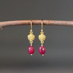 "Elegant smooth Red Ruby oval stones are wire wrapped with 18k gold vermeil pins onto 24k gold vermeil rose flower links. These dangle from 18k gold vermeil earwires. Choose from balled gold earwires (as shown and sent with stoppers for the ends of the wires) or plain 24k gold vermeil leverback earwires (these close in the back). Wonderful lightweight dangle earrings. The perfect go-to-earrings for any occasion. Gold flower links: 7x12mm Red Ruby stones: 7x8mm Total length of earrings: 1 3/8\" L Ruby Earrings In Yellow Gold For Gift, Ruby Yellow Gold Earrings For Gift, Yellow Gold Ruby Earrings For Gift, Rose Gold Ruby Earrings For Gifts, Red Gemstone Gold-plated Earrings, Gold Wire Wrapped Flower Earrings Gift, Red Gemstone Gold Plated Earrings, Yellow Gold Wire Wrapped Earrings For Gift, Ruby Earrings With Ear Wire For Gift