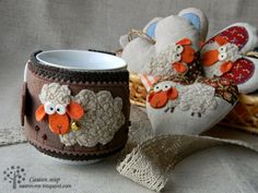 two stuffed animals are sitting next to a coffee cup on a tablecloth covered surface