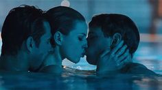 three people are kissing in the water