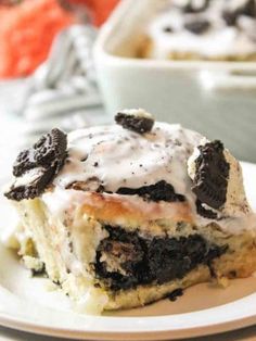 a close up of a piece of cake on a plate with ice cream and oreo cookies