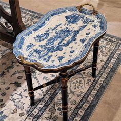 a blue and white tray on top of a wooden table next to a rug in a room