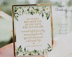 a sign that is sitting on top of a wooden table with white flowers and greenery