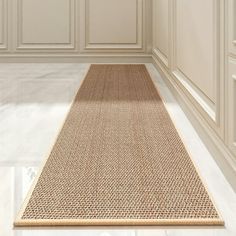 a beige rug is in the middle of a room with white walls and flooring