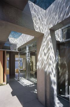 an open room with glass doors and sunlight streaming through the ceiling