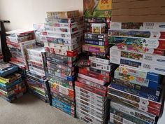 a pile of video games sitting on top of a carpeted floor next to a window