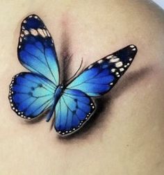 a blue butterfly on the back of a woman's shoulder