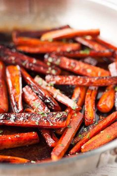 cooked carrots in a pan with seasoning sprinkled on top