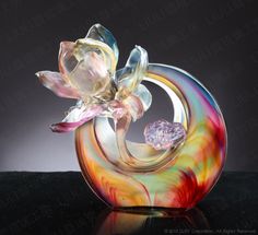 a colorful glass vase with a flower on the bottom and a diamond in the middle