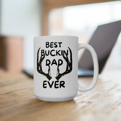 a white coffee mug with the words best buckin rap ever on it sitting on a wooden table