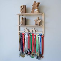 a wooden shelf with medals on it and a star hanging from the wall next to it