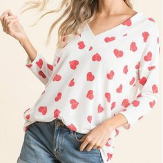 White & Red Heart V-Neck Three-Quarter Sleeve Top Color: Red & White Material: 95% Polyester 5% Spandex Fit: True To Size Spring Heart Print V-neck Top, V-neck Top With Heart Graphic For Summer, Casual V-neck Top With Heart Print, Red Tops With Heart Graphic For Spring, Red Heart Graphic Top For Spring, Red Heart Print Casual Top, Trendy Red Top With Heart Print, Casual Red Heart Print Top, Casual Red Top With Heart Print