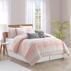 a bed in a bedroom with pink walls and white curtains