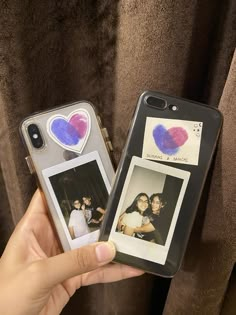 someone holding up two cell phones with pictures on them, one has a heart shaped sticker