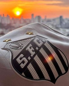 the back end of a motorcycle parked in front of a cityscape at sunset