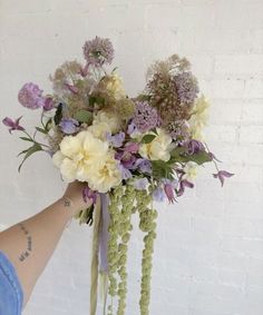 a person holding a bouquet of flowers in their hand