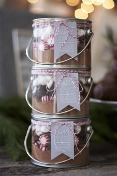 three mason jars filled with candies and marshmallows are stacked on top of each other