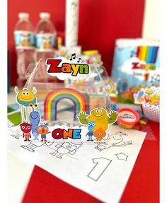 an assortment of cut out toys sitting on top of a red table with other items in the background