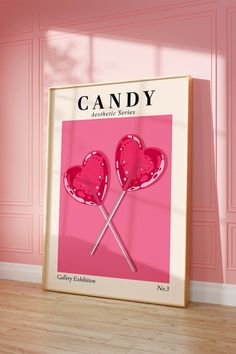 a pink poster with two heart shaped lollipops on it in front of a pink wall