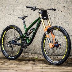 a green and yellow mountain bike leaning against a wall