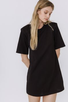 This Shoulder Pad T-Shirt Dress is a wardrobe must-have! Featuring a stylish round neckline, short sleeves, and a boxy silhouette, it's the perfect addition to any outfit. Our unique shoulder pad insert adds structure and a touch of sass, making this dress a standout. With its comfortable fit and comfortability, you'll look amazing no matter what the occasion. Show off your fashion-forward style with this shoulder-pad t-shirt dress! Shoulder pad inserted Round neckline Short sleeves Boxy silhoue Black Relaxed Fit T-shirt Dress With Short Sleeves, Black Relaxed Fit T-shirt Dress With Crew Neck, Black Relaxed Fit Dress For Everyday, Black Crew Neck T-shirt Dress For Spring, Black Oversized Crew Neck T-shirt Dress, Oversized Black Crew Neck T-shirt Dress, Oversized Short Sleeve T-shirt Dress, Knit Loungewear, Strapless Bodycon Dress