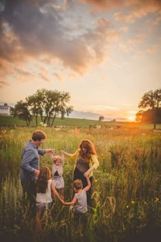 a family standing in a field at sunset