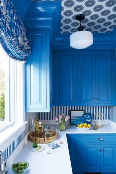 a kitchen with blue cabinets and white counter tops