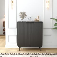 a black cabinet sitting on top of a hard wood floor next to a white wall