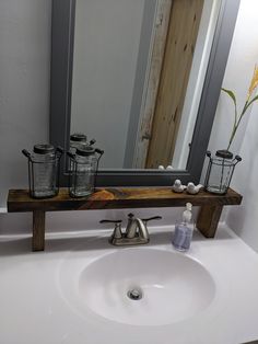 a bathroom sink under a large mirror with soap dispensers on the counter