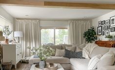 a living room filled with furniture and pictures on the wall