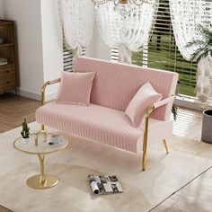 a living room with pink couches and chandelier hanging from the ceiling over a coffee table