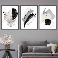 three black and white paintings hanging on the wall above a couch in a living room