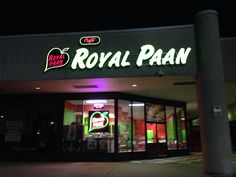 the royal paan is lit up at night with neon signs on it's front