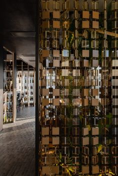 the interior of a restaurant with wooden floors and large mirrors on the wall behind it