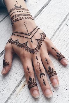 a woman's hand with henna tattoos on it