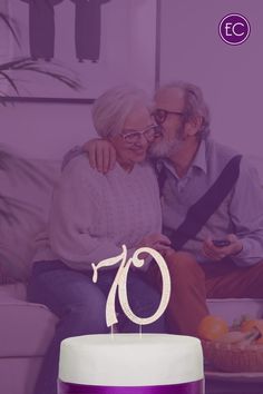 an older couple sitting on a couch next to a cake with the number 70 on it