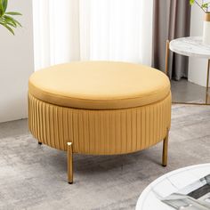 a round ottoman sitting on top of a carpeted floor next to a table with a potted plant