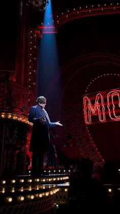 a man standing on top of a stage in front of a sign that says mom