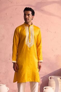 SHRESTHA BY VASTRAMAY Men's Yellow Silk Machine Embroidered Kurta Luxuriate in this vibrant yellow kurta, featuring intricate machine embroidery. Made from a silk blend, this kurta boasts a comfortable and stylish fit. Pair it with a dhoti or pajamas for a complete traditional look. Key Features Yellow silk blend with machine embroidery Mandarin collar Long sleeves Side slits Pockets Specifications Sleeve Length: Full Sleeves Top Shape: Straight Top Hemline: Straight Top Length: Knee Length Mate Chanderi Kurta With Gold Embroidery Long Sleeve, Chanderi Long Sleeve Kurta With Gold Embroidery, Yellow Chanderi Kurta With Floral Embroidery, Long Sleeve Kurta With Gold Embroidery For Navratri, Yellow Chanderi Long Sleeve Kurta, Yellow Long Sleeve Chanderi Kurta, Yellow Traditional Wear With Straight Kurta And Floral Embroidery, Unstitched Gold Embroidered Kurta For Festivals, Unstitched Gold Embroidery Kurta For Festivals