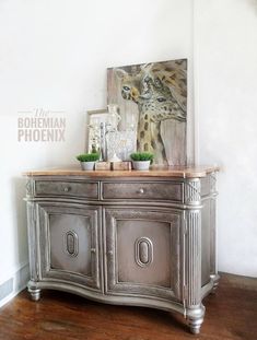 a silver sideboard with plants and pictures on top