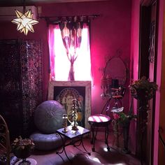 a living room filled with furniture and pink lighting on the walls, windows, and curtains