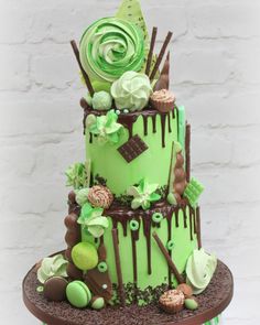 a three tiered cake with green icing and chocolate decorations