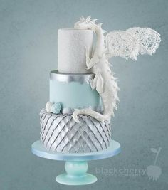 a three tiered cake with white frosting on top