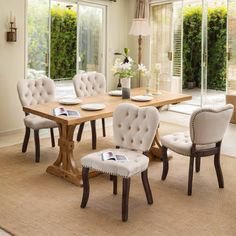 a dining room table and chairs in front of sliding glass doors